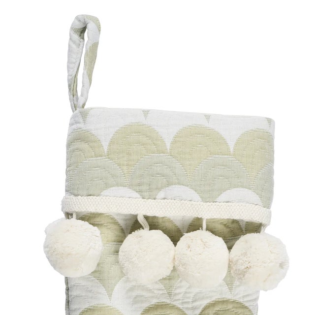 Trimmed with winter-white pom-pom fringe, the tonal, tactile stripes of Schumacher’s Prairie Hills fabric suggest a winter...