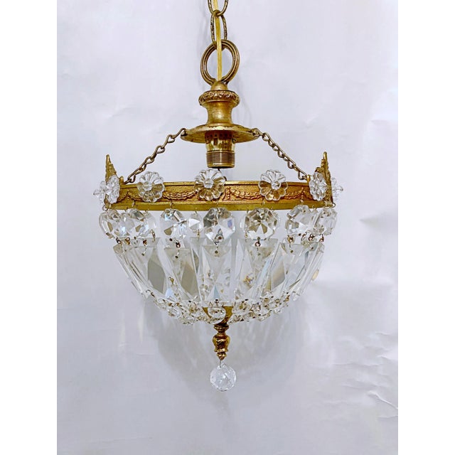 This is a basket chandelier with ornate brass rim decorated with crystal rosettes and 30% leaded graduated octagon chain....