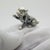 This vintage silver decorative object depicts a puppy dog figurine miniature with a raised paw, crafted as a dollhouse...