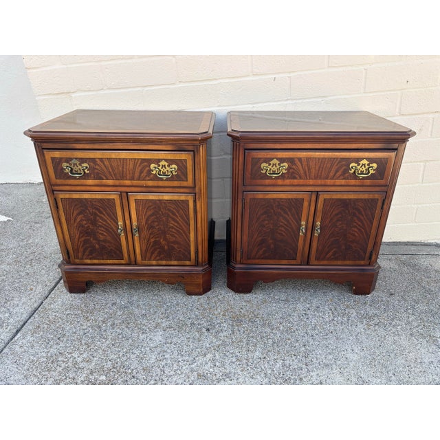 Pair of Drexel Heritage Heirloom collection Chippendale-style nightstands featuring mahogany wood and brass hardware....