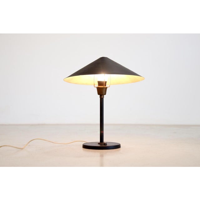 Nice modernist table lamp from Denmark. Made of black lacquered metal with brass details. We have not been able to trace...