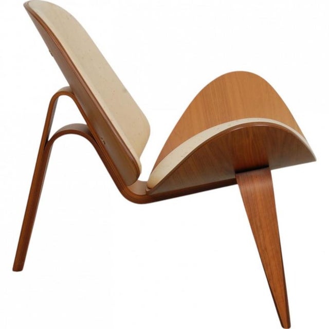 Hans Wegner CH07 Shell chair with a frame of walnut and an upholstered seat and back in natural leather. The chair is from...