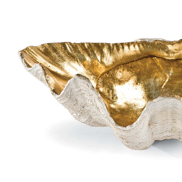 A large clam shell with gold interior works as a decorative bowl with beachy charm. Position on an entryway table or...