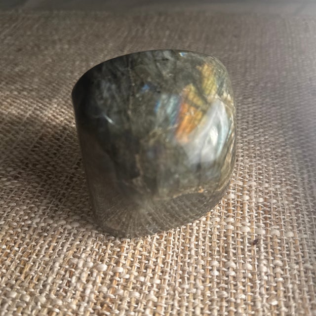 A striking polished piece of natural labradorite, celebrated for its captivating play of color known as labradorescence....