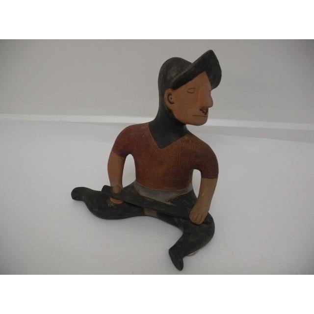 Celebrate the spirit of ancient artistry with this striking ceramic figurine, a seated conquistador rendered with bold...