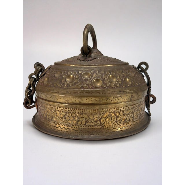 Brass betel box with repoussé decoration of plant ornaments, known as a "jali paan dan", India, early 20th century. This...