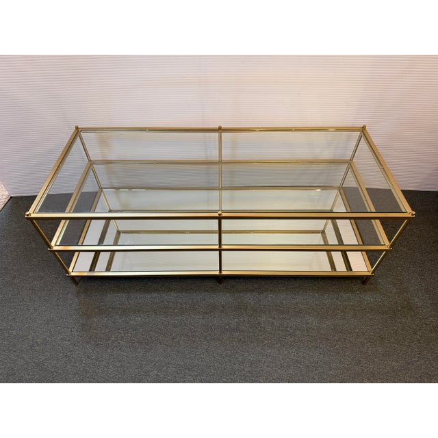 Design Plus Gallery presents a Terrace Coffee Table from West Elm. The Antique Brass finish, glass top, and shelf rest on...