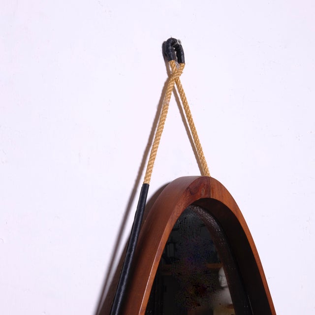 Beautiful oval vintage mirror, 1950s in teak with rope and leather details. Dimensions: Height 84 cm Height with rope 105...