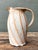 This sculptural studio pottery pitcher is a compelling testament to artisanal skill and organic beauty. The hand-thrown...