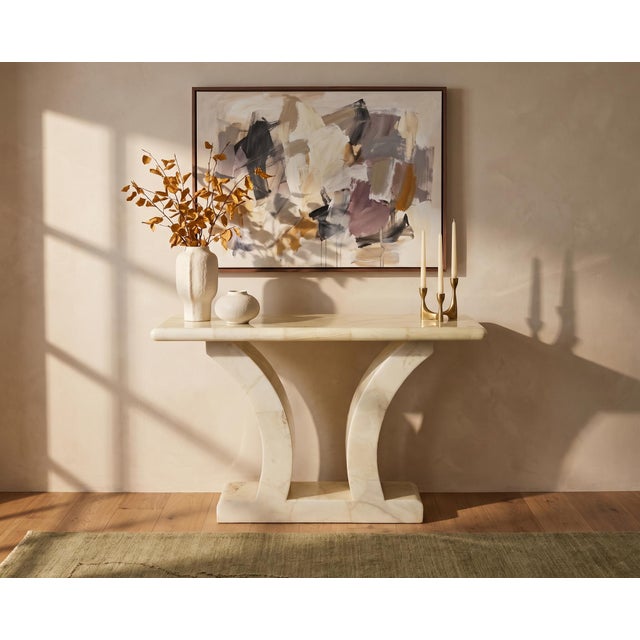 A petite sculptural console table presented as circa 1960s, distinguished by a polished cream-white marble surface, softly...