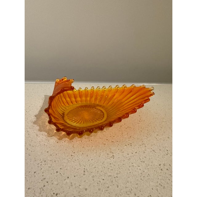 Vintage amber pressed-glass decorative bowl featuring a sculptural peacock design, with the bird's dramatic fanned tail...
