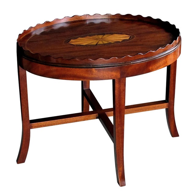 The large mahogany oval tray centering an impressive satinwood shell motif surrounded by rosewood banding; raised on a...