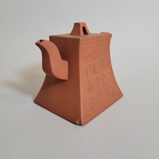 A sculptural Chinese Yixing clay teapot dating to the 1970s-80s, distinguished by its sharply tapered rectangular form,...