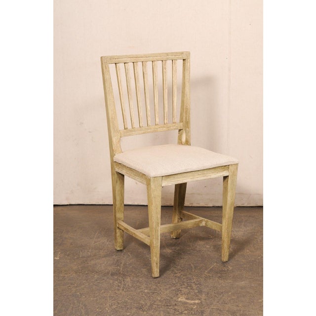 A Swedish Gustavian pair of slatted back side chairs from the early 19th century. These antique chairs from Sweden have...