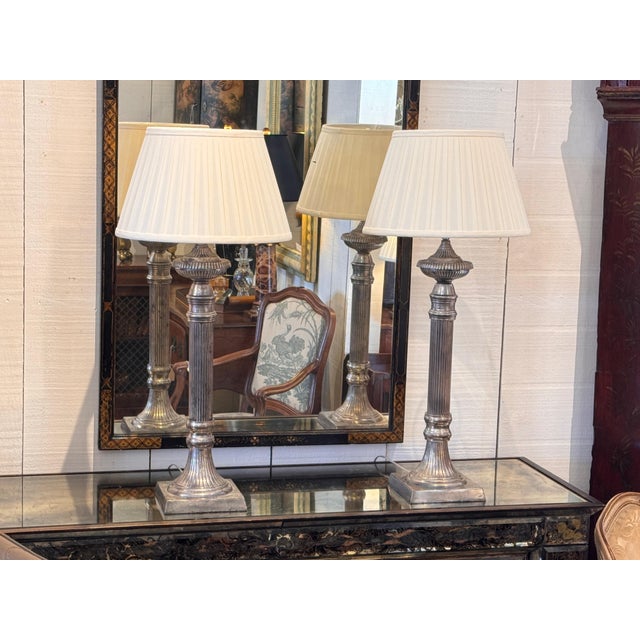 A pair of column-form lamps with vertically fluted shafts rising from square stepped bases and finished with ring-turned...