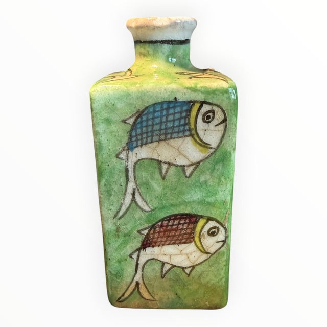 A Persian ceramic vase from the Qajar dynasty. Brightly painted with animated fish patterns on a jade green ground with...