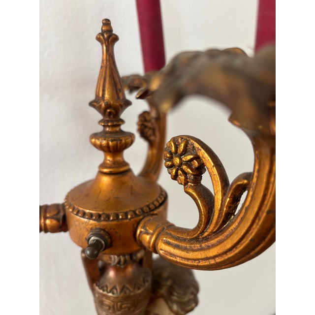 Antique Neoclassical figural candelabra table lamp, featuring a cherub or putti figurine holding a candelabra, set on a...