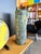 This cylindrical art glass vase features a heavily textured scavo finish achieved through the application of mineral salts...