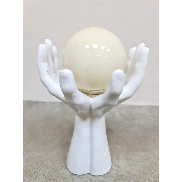 Hands up! This crazy ceramic hands lamp in which two hands hold a glass light bulb is a feast for the eyes. Period:...