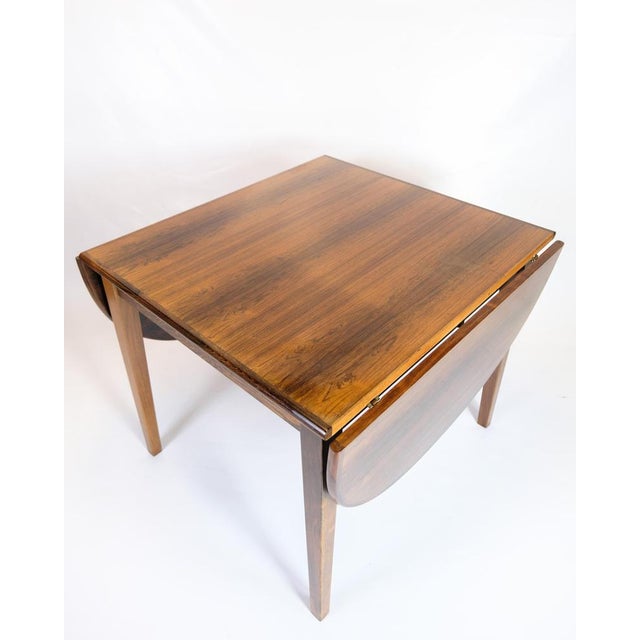 Dining table from the 1960s made of rosewood with beautiful and vibrant grain. The table has two oval folding sides, which...