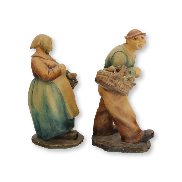 Pair of early 20th century Italian ceramic sculptures by Guido Cacciapuoti, depicting peasant figures carrying baskets...