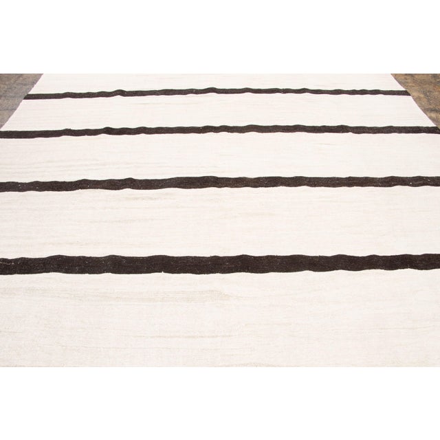 Handwoven from recycled vintage hemp and originating from Turkey circa 1950-1959, this nearly 10x13 vintage kilim joins...