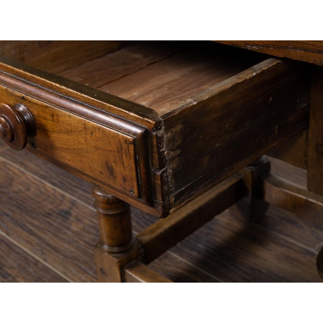 An English walnut side table from the 19th century with single drawer, turned baluster legs, plain side stretchers and...