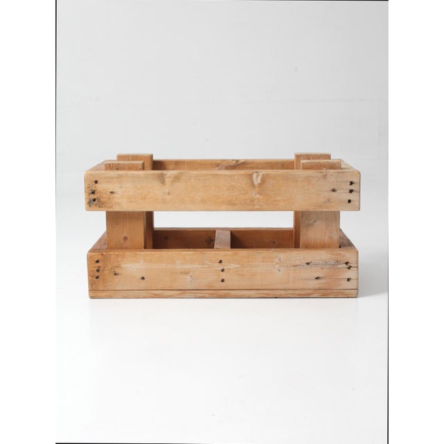 A vintage industrial wood crate with a grounded, utilitarian presence, defined by thick plank construction and a...