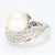This is a luxurious bypass cocktail ring with a large white pearl at the center and a sea of thirty diamonds beneath...