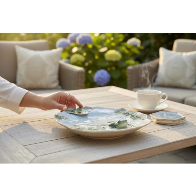 A sculpted porcelain platter from the Franz Porcelain Amphibia series, model XPI-690, presenting high-relief frogs and...