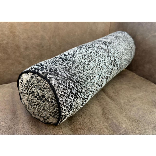A bolster in snake scale fabric does not try to blend in. Placed on a sofa arm, a bed, or a reading chair, it reads...