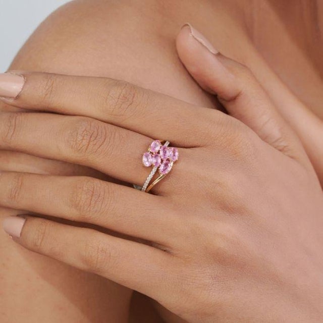 This modern bypass cluster ring features 1.66 carats of oval cut pink sapphires, set in 14K yellow gold. Each sapphire...