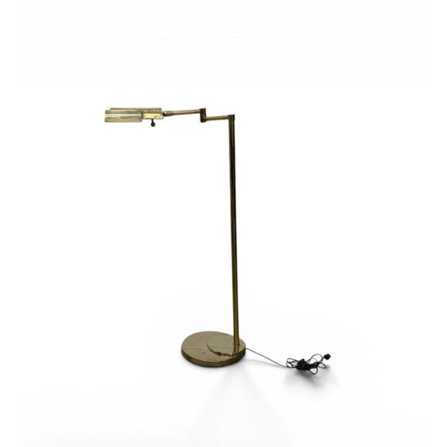Mid-century adjustable floor lamp in solid brass construction. Slender upright form with articulated arm and directional...
