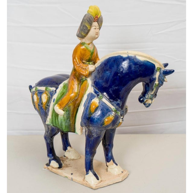 Impressive large-scale Chinese sancai ("three-color") glazed pottery sculpture depicting a caparisoned horse with a seated...