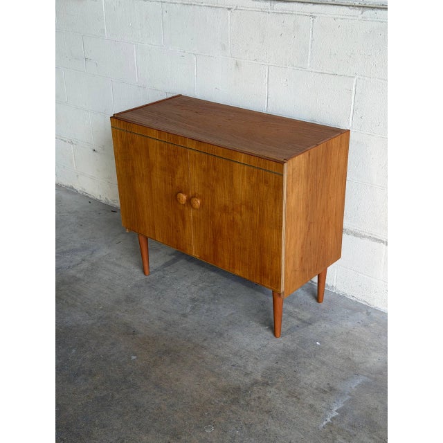 Beautiful vintage Danish modern cabinet crafted in warm teak with clean Scandinavian lines and elegant tapered legs. This...