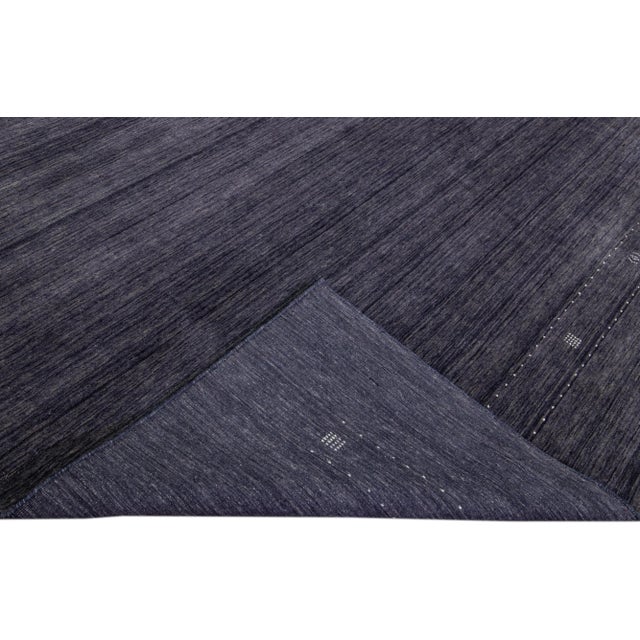 Beautiful modern Gabbeh style hand-Loom wool rug with the charcoal blue color field. This Gabbeh-style rug has white...
