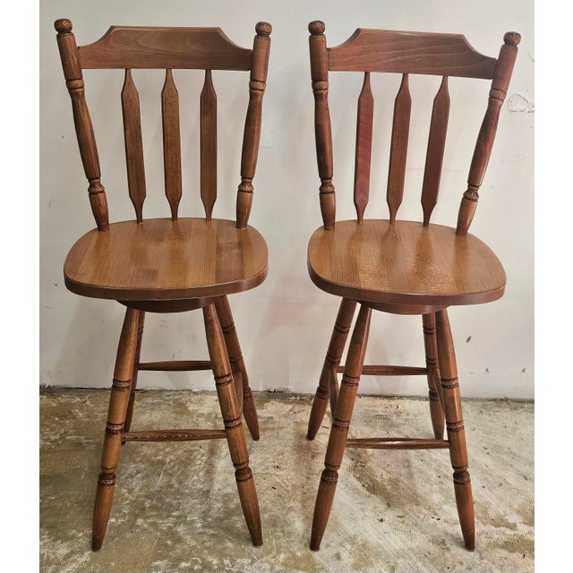 Pair of Mid Century Arts and Crafts Style Stained Maple Swivel Bar Stools. Measures 19" in width, 19" in depth and 47.25"...