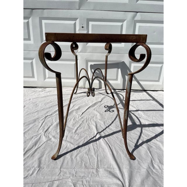 A single vintage rectangular iron console table base featuring scrolled legs and stretchers. Features a charming patina...