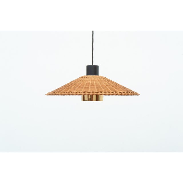 Ceiling light with a hand-woven willow shade and a brass tube that focuses the light. The combination of natural materials...