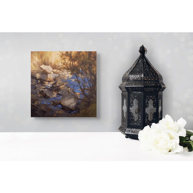 This oil painting captures a serene stream scene, where smooth stones emerge from the water, surrounded by delicate...