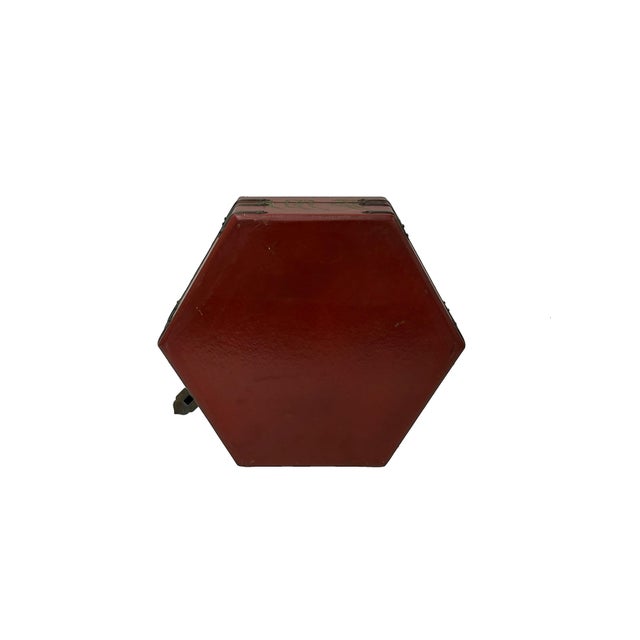 This hexagonal wooden box features a deep red lacquered finish, accented by aged metal hardware and decorative corner...