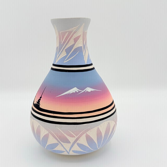 A beautifully graphic signed Navajo pottery vase, painted in the atmospheric colors of a Southwestern sunset. Soft layers...