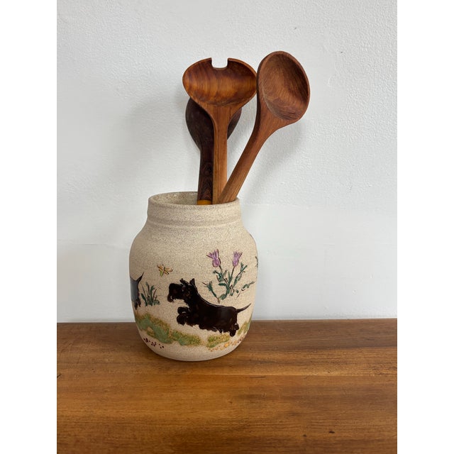 Delightful stoneware vase with an etched and hand painted scene which includes curious scottie dogs, dragonflies, and...