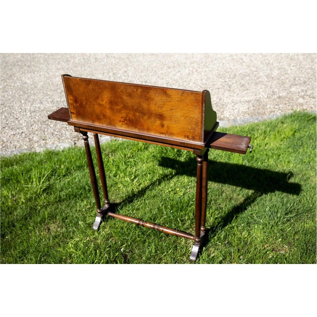 Antique mahogany bookstand or lectern-style side table with a rich reddish-brown patina with visible grain, two pull-out...