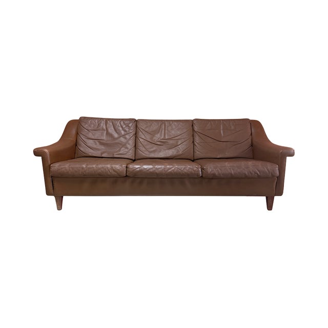 Vintage mid-century Danish modern brown leather three-seater in the manner of Aage Christiansen's "Matador" sofa. Features...