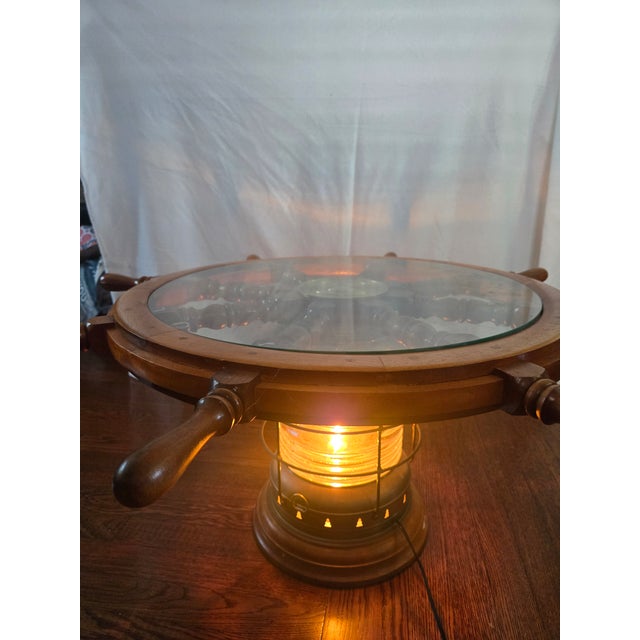 Great vintage ship wheel coffee table with light up lantern base. Brass lantern and brass center cap. 36" beveled edge top...