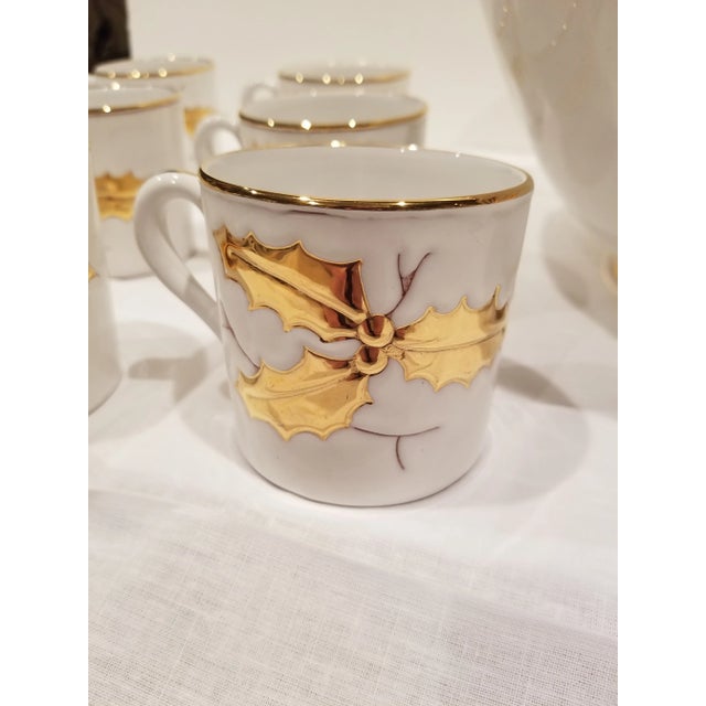 Pretty white Italian ceramic eggnog set....12 gold decorated holly themed mugs and a gilt decoated holly themed large bowl.