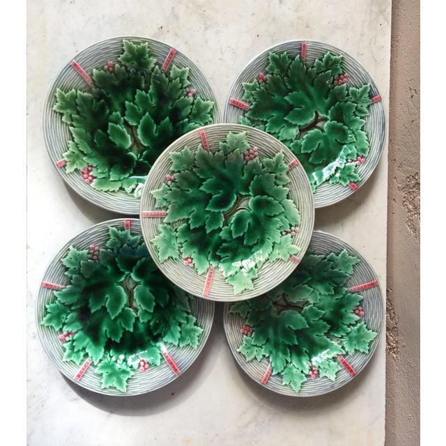 Charming French Majolica plate with grapes and leaves on a grey basket weave background signed Gien, circa 1890. Four...