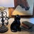 This is a 19th-century Black Jackfield Staffordshire spaniel figurine featuring a glossy black glaze and gilded gold...