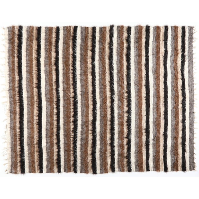 This handmade kilim blends tribal tradition with modern minimalism through its bold stripe design. Woven in natural wool...